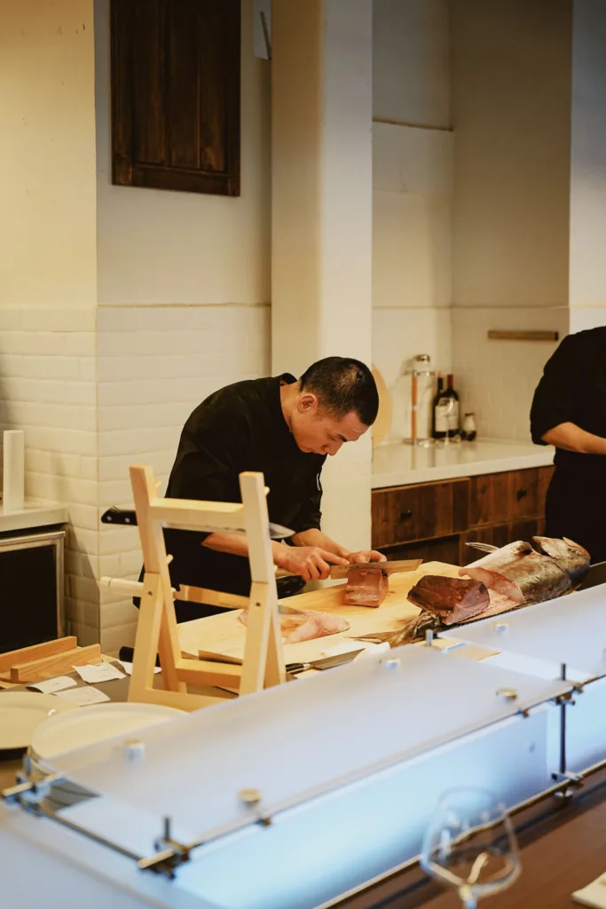 Bloom Cuisine chefs preparing whole fish at the counter