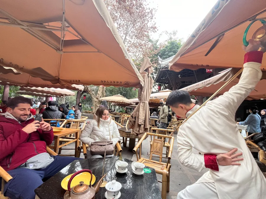 Guests enjoying Chengdu tea-house culture with a local performer