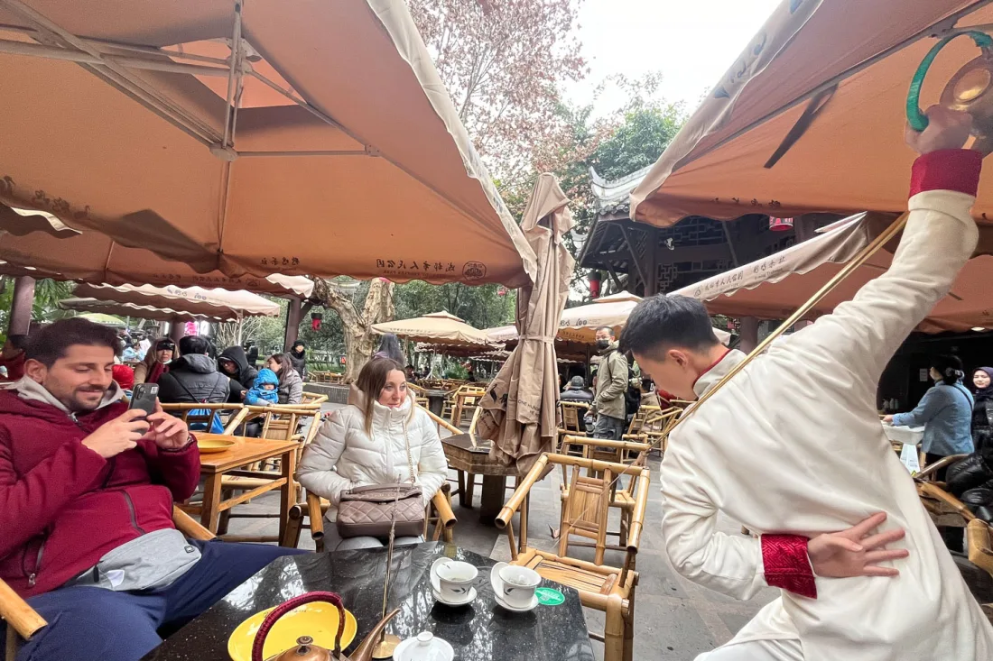 A traditional performance beside guests at a Chengdu tea house