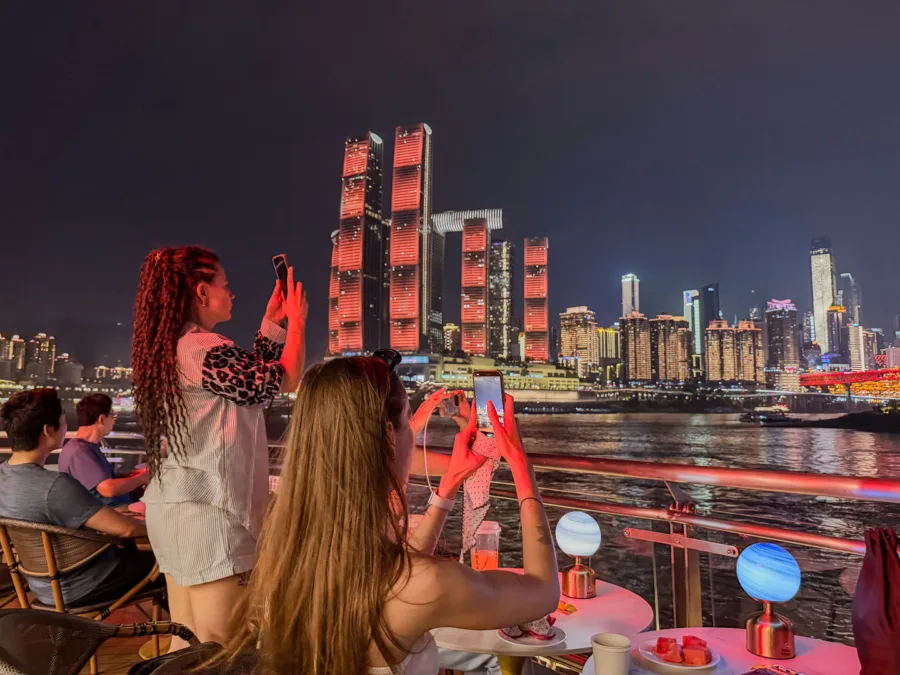 Guests photographing the Chongqing skyline from a Two Rivers Cruise