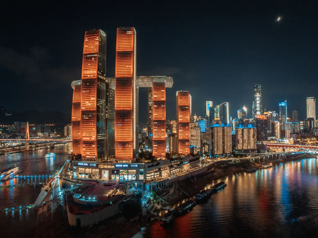 Raffles City and the illuminated Chongqing skyline seen from Chaotianmen Plaza at night