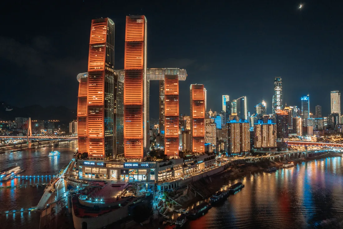 Raffles City and the illuminated Chongqing skyline seen from Chaotianmen Plaza at night