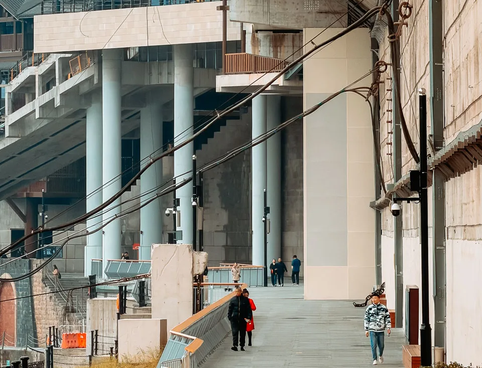 An elevated walkway beside old neighbourhood buildings near Chaotianmen riverbank