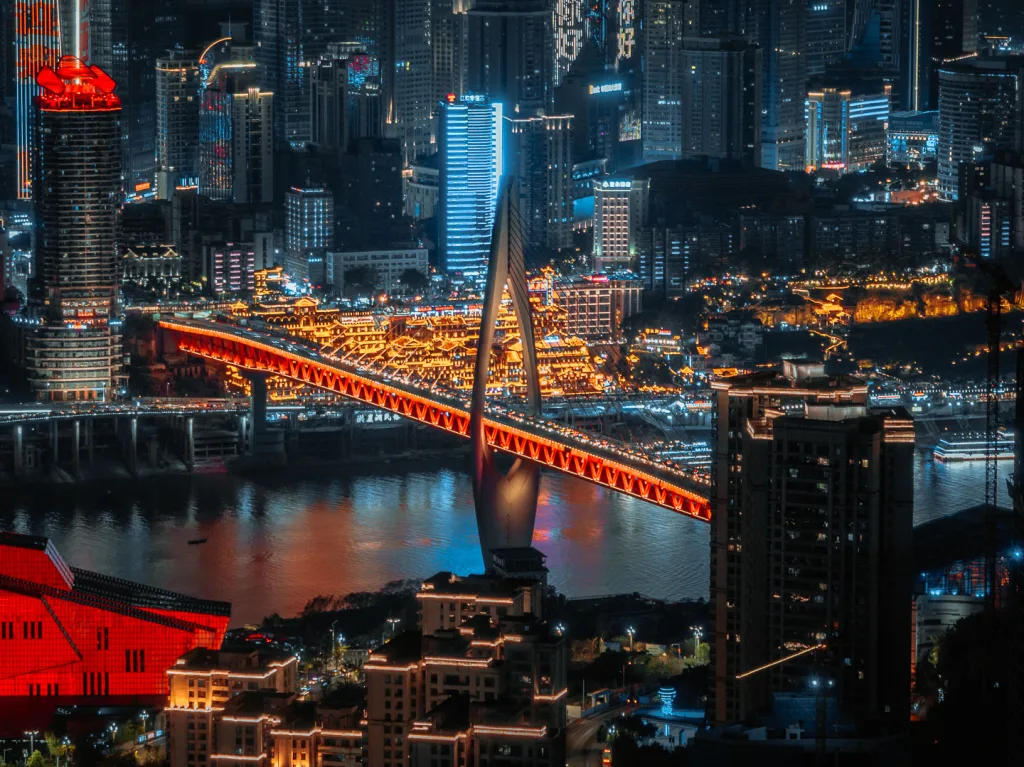 Hongya Cave and Qiansimen Bridge glowing beside the river at night