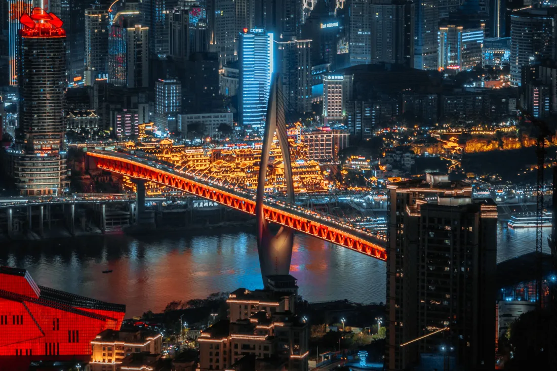 Hongya Cave and Qiansimen Bridge glowing beside the river at night