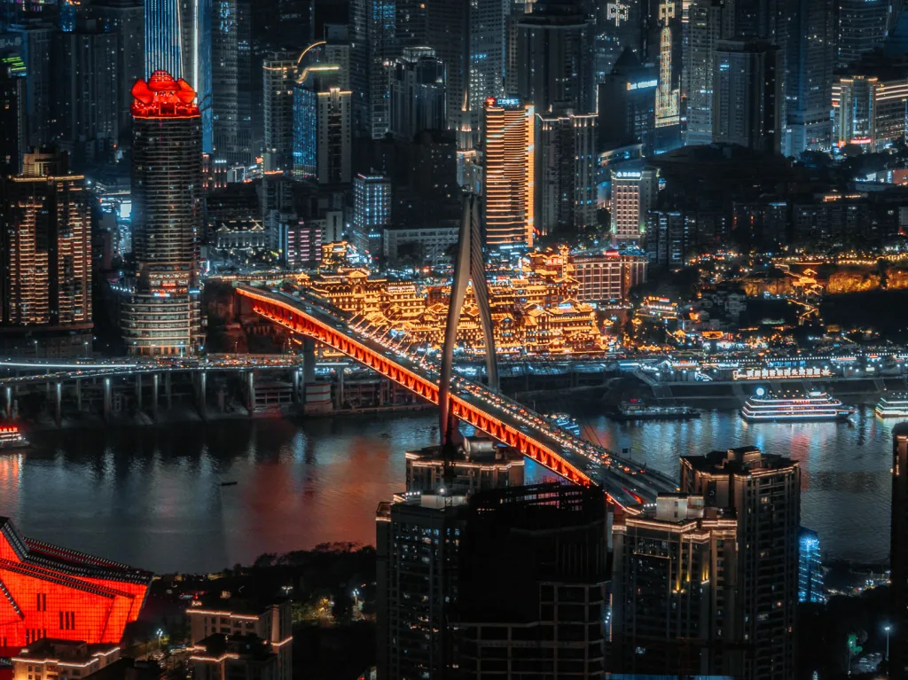 Hongya Cave and Qiansimen Bridge glowing beside the river at night