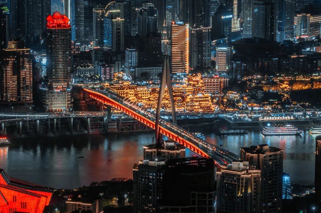 Hongya Cave and Qiansimen Bridge glowing beside the river at night