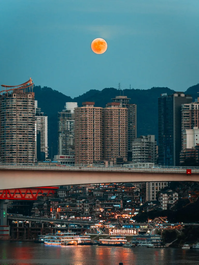 The moon rising above Hongya Cave and the Chongqing riverfront
