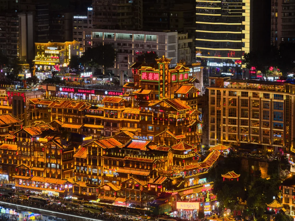 Hongya Cave illuminated beside the river in Chongqing at night