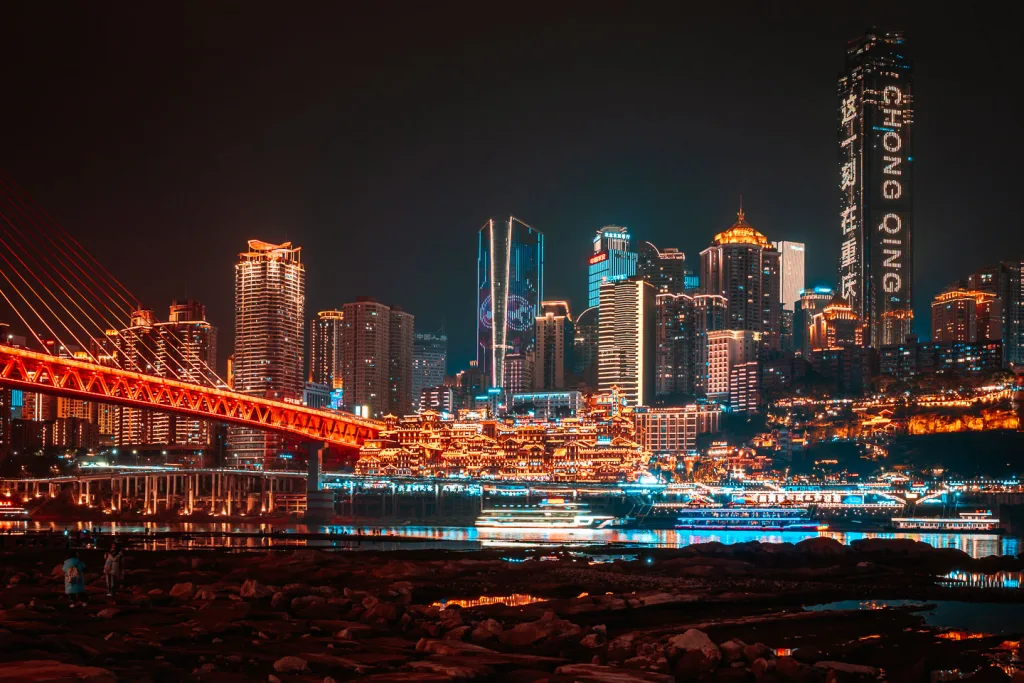 Hongya Cave illuminated beside the river in Chongqing at night