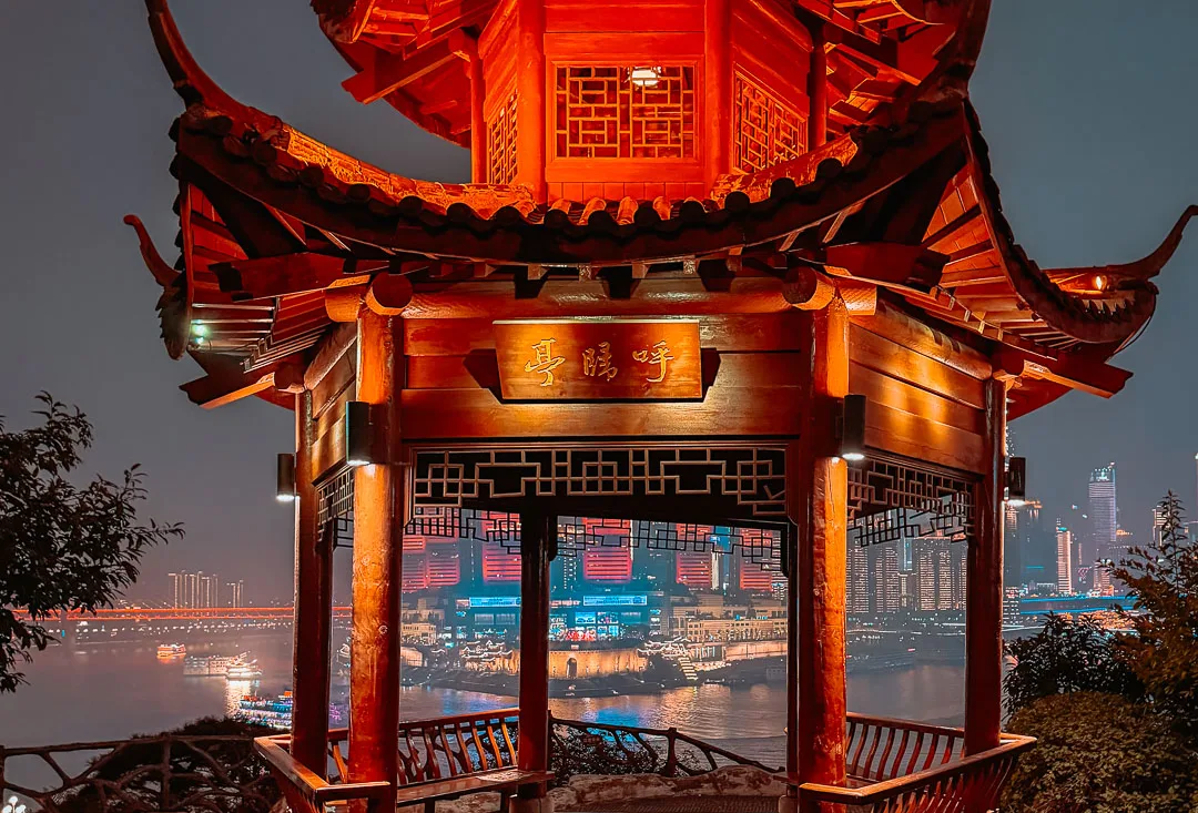 Chongqing river skyline framed by a pavilion in Huguishi Park