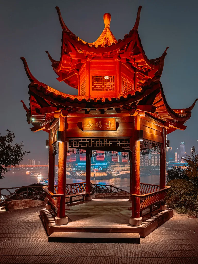 Chongqing river skyline framed by a pavilion in Huguishi Park