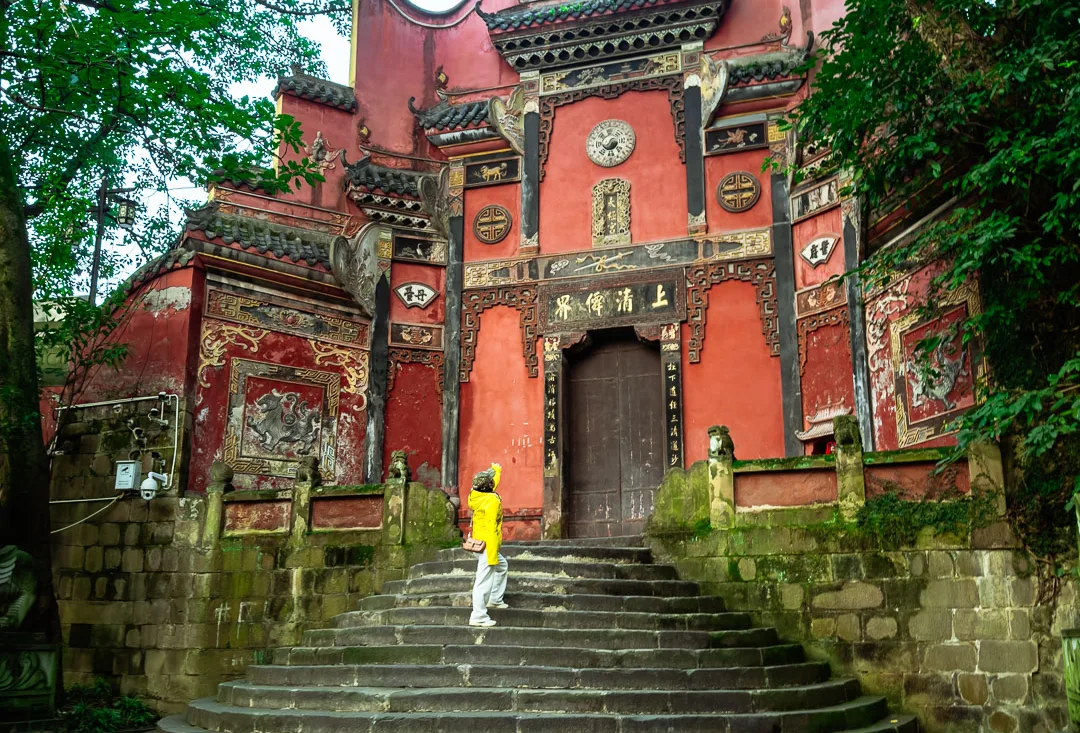 Stone steps leading to a historic red temple gate in Chongqing
