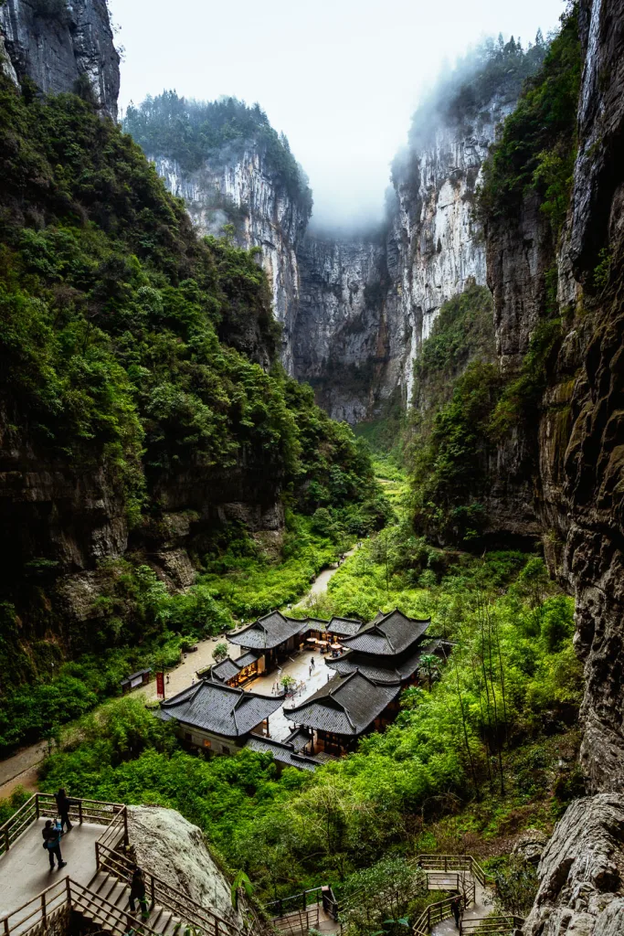 Karst cliffs and traditional courtyard buildings at Wulong Three Natural Bridges