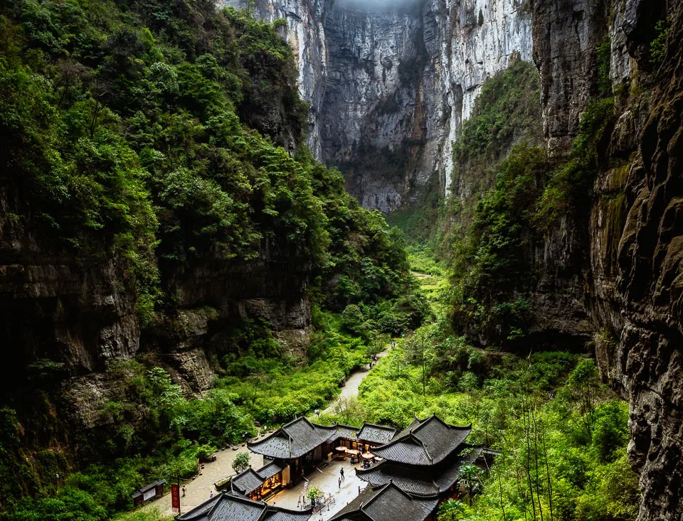 Karst cliffs and traditional courtyard buildings at Wulong Three Natural Bridges