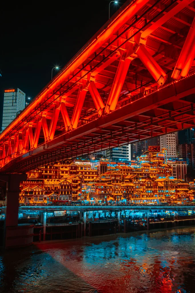 Qiansimen Bridge glowing red above Hongya Cave at night
