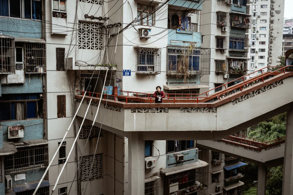 Layered outdoor walkways winding through a dense Chongqing residential building