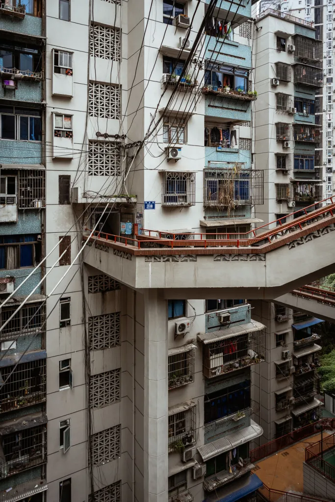 Layered outdoor walkways winding through a dense Chongqing residential building