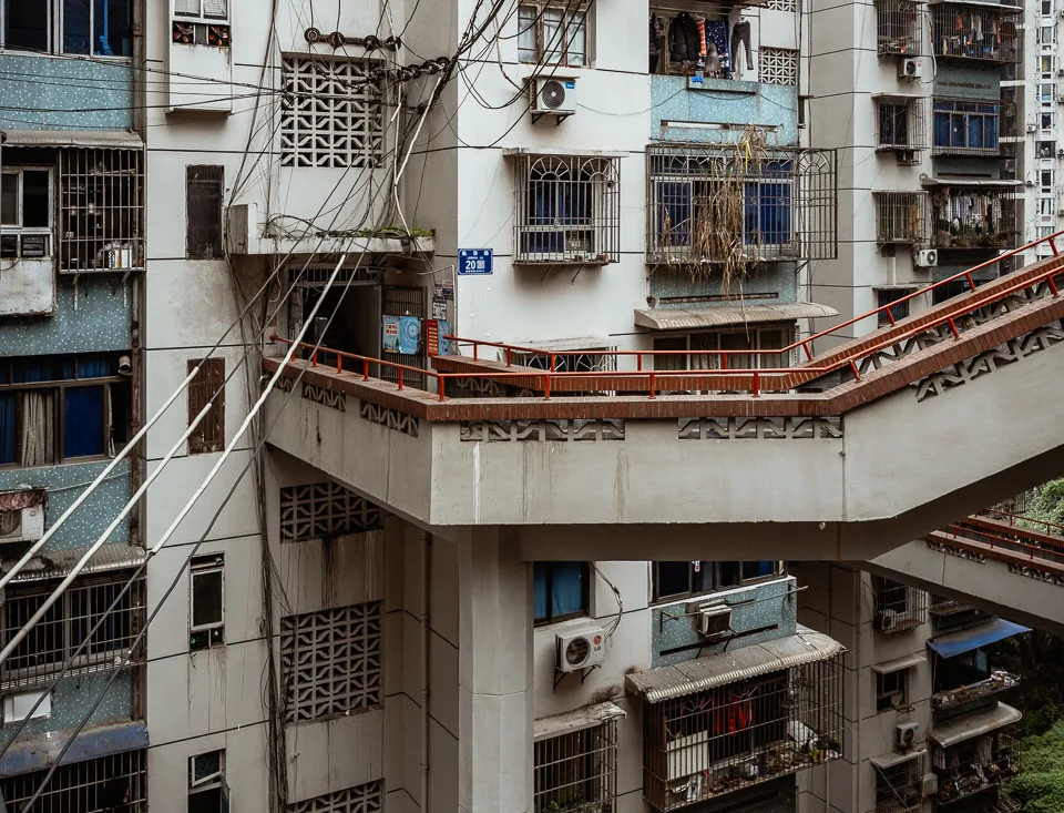 Layered outdoor walkways winding through a dense Chongqing residential building