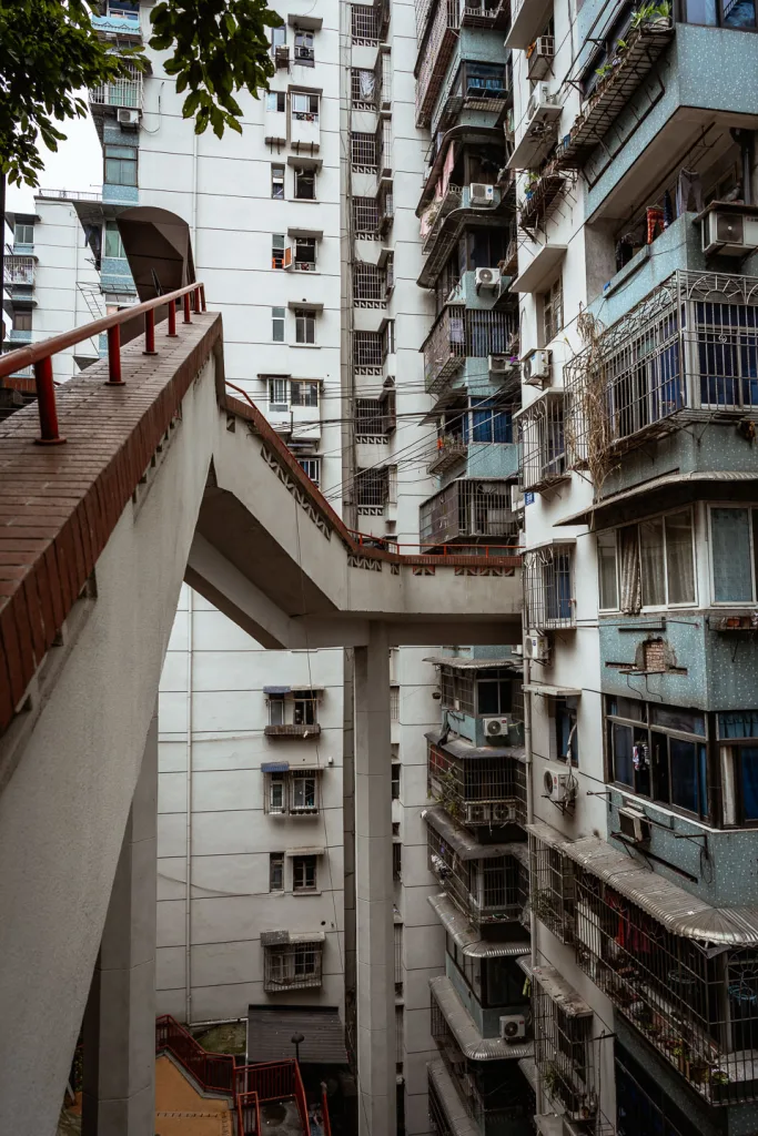 Layered outdoor walkways winding through a dense Chongqing residential building