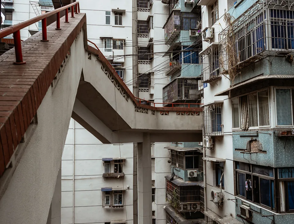 Layered outdoor walkways winding through a dense Chongqing residential building
