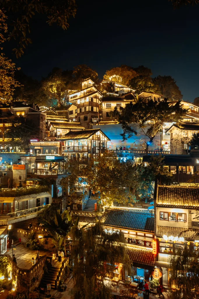 Traditional hillside buildings illuminated along Xiahao Lane at night