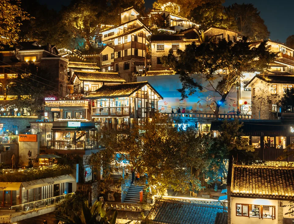 Traditional hillside buildings illuminated along Xiahao Lane at night