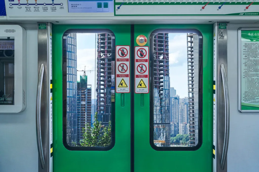 High-rise buildings framed by the doors of Chongqing Metro Line 2