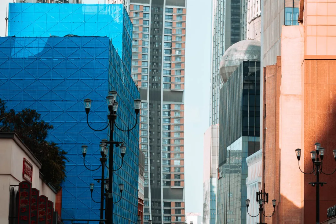 Pedestrians walking between modern towers in Chongqing's Jiefangbei district