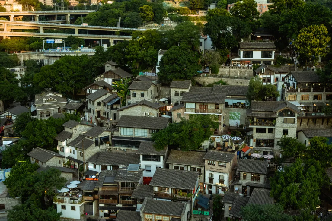 Traditional hillside homes surrounded by green mountains near Chongqing