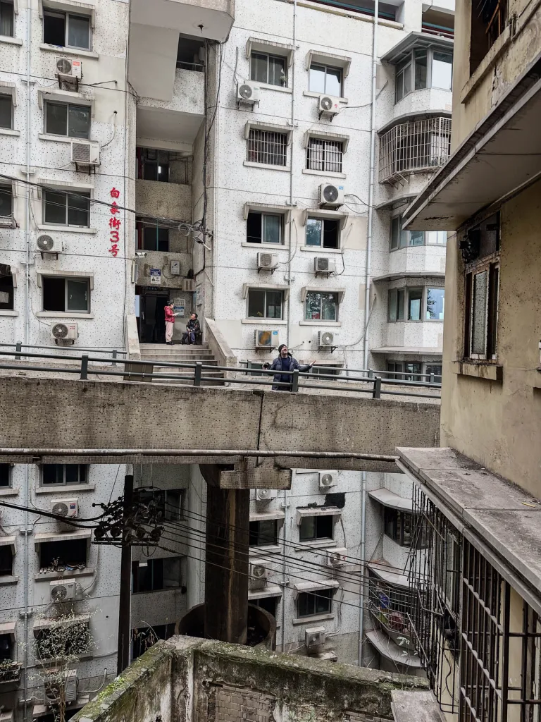 Dense apartment windows surrounding a narrow Chongqing courtyard