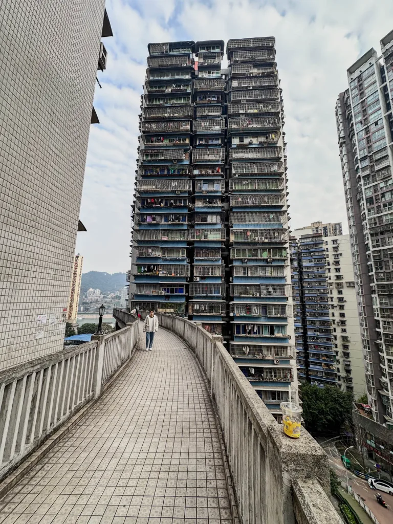 A pedestrian walkway leading between tall residential buildings in Chongqing