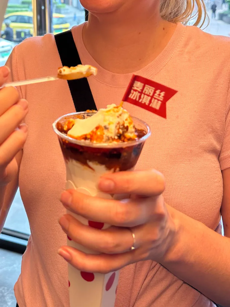 A traveller holding a cup of spicy Chongqing street food