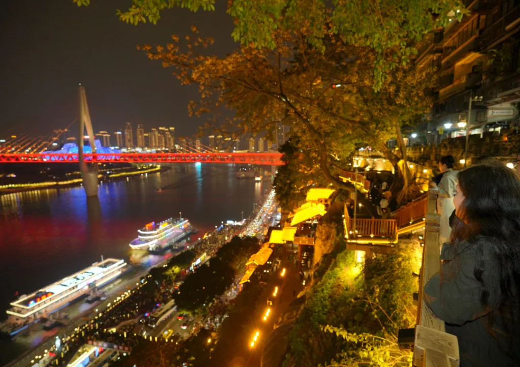 A traveller posing among Chongqing skyscrapers, neon lights and riverside night views
