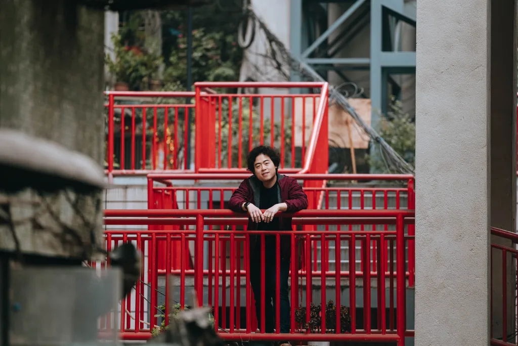 A portrait among the red walkways of a layered Chongqing residential neighbourhood