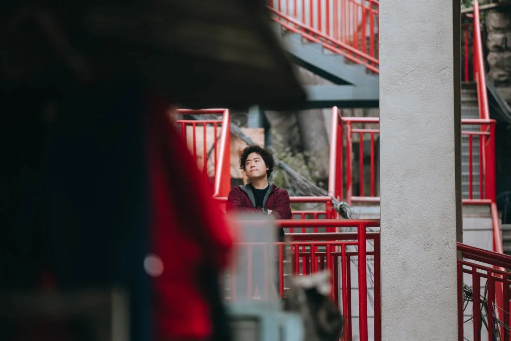 A portrait among the red walkways of a layered Chongqing residential neighbourhood