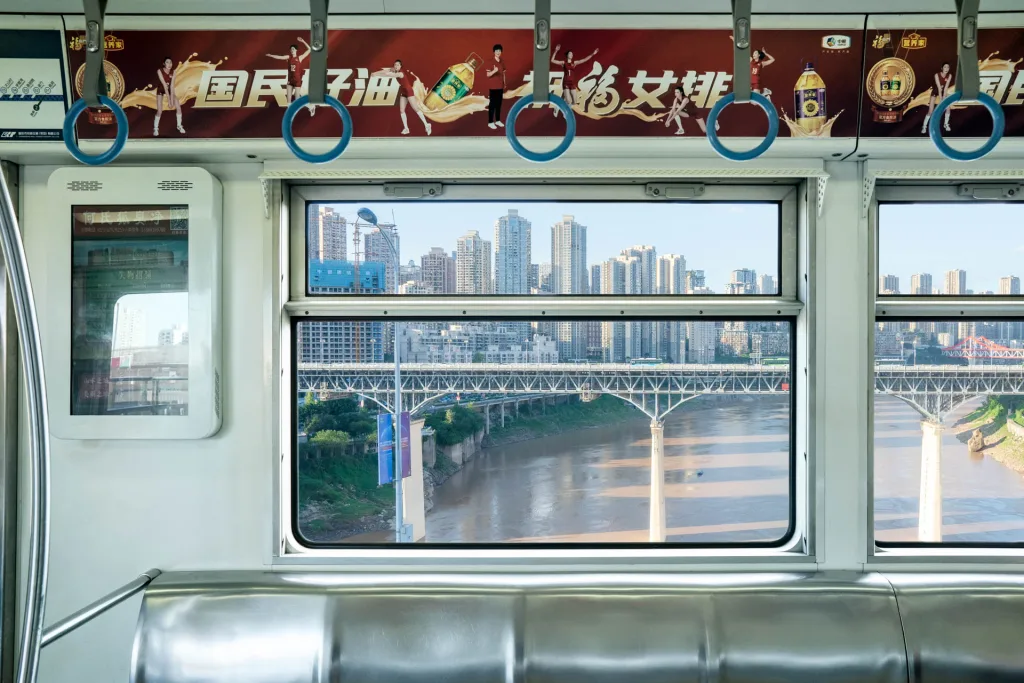 A Chongqing Metro Line 3 carriage framing a bridge across the river