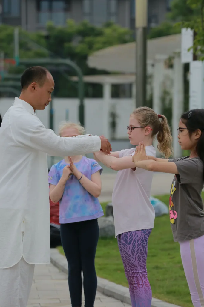 Young guests learning martial arts movements in Chengdu