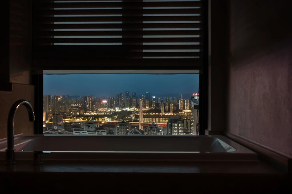 Bathtub overlooking the illuminated Chongqing skyline at night
